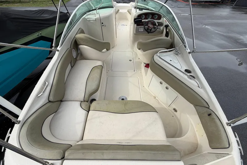 Slide: The Image of 2005 Sea Ray 240 Sundeck interior with spacious seating and helm, showcasing elegant design. - 13