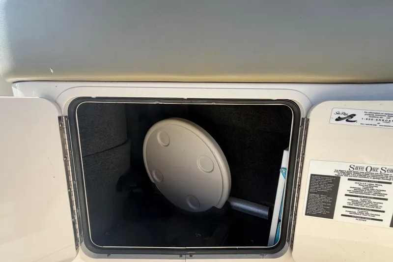 Slide: The Image of Storage compartment on a 2005 Sea Ray 240 Sundeck boat, featuring a round table. - 19
