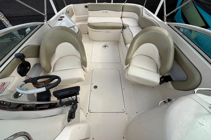 Slide: The Image of 2005 Sea Ray 240 Sundeck interior with beige seating and steering wheel. - 21