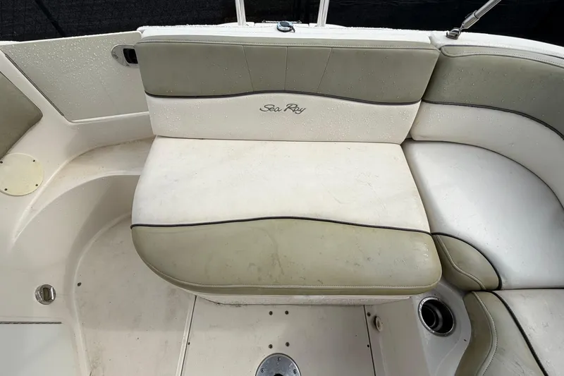 Slide: The Image of 2005 Sea Ray 240 Sundeck boat seating area with beige upholstery and cup holder. - 24
