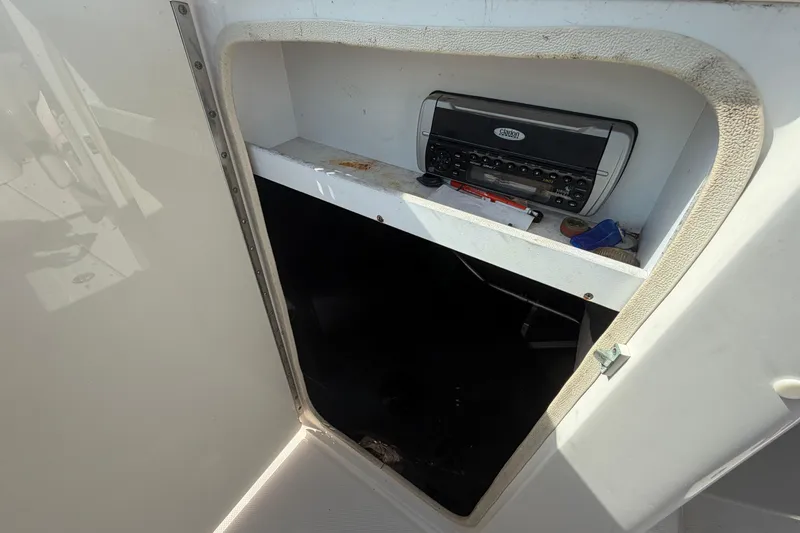 Slide: The Image of 2005 Sea Ray 240 Sundeck interior storage with stereo system and miscellaneous items. - 43
