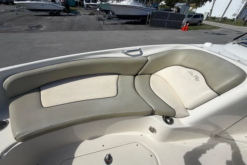 Slide: The Image of 2005 Sea Ray 240 Sundeck boat interior with cushioned seating area. - 48