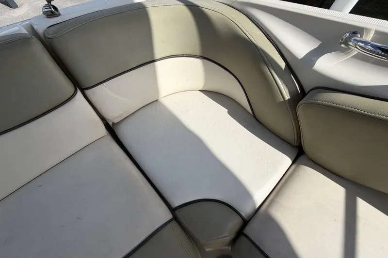 Slide: The Image of 2005 Sea Ray 240 Sundeck boat seating with beige and white upholstery. - 68