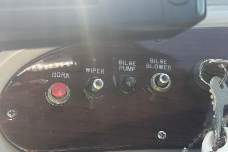 Slide: The Image of Control panel of a 2005 Sea Ray 240 Sundeck with switches and keys. - 30