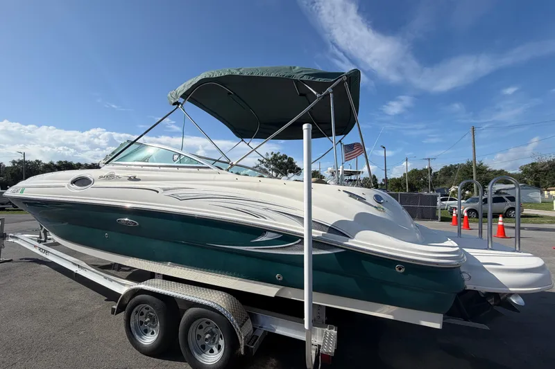 Slide: The Image of 2005 Sea Ray 240 Sundeck boat on trailer under blue sky. - 7