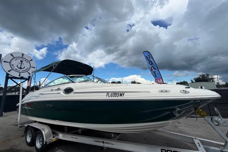 The Image of 2005 Sea Ray 240 Sundeck boat on trailer under cloudy sky, ready for sale. - 0