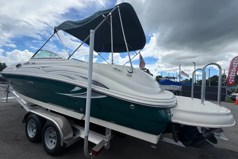 Slide: The Image of 2005 Sea Ray 240 Sundeck boat on trailer under cloudy sky. - 7
