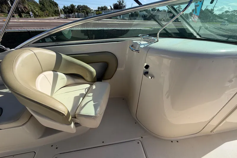 Slide: The Image of 2005 Sea Ray 240 Sundeck interior with beige seating and helm area. - 35