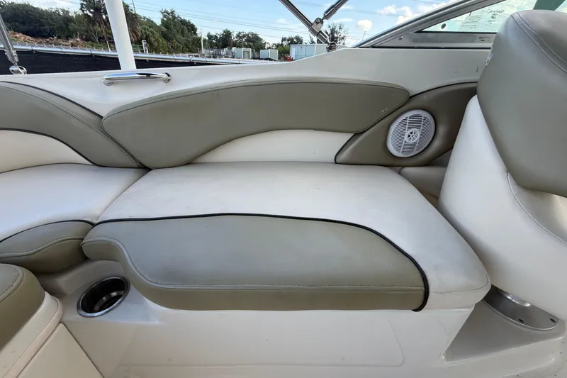 Slide: The Image of 2005 Sea Ray 240 Sundeck interior seating with cup holder and speaker. - 65