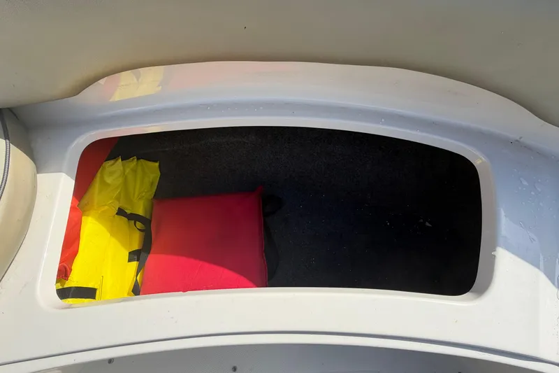Slide: The Image of Storage compartment in a 2005 Sea Ray 240 Sundeck with life jackets inside. - 55