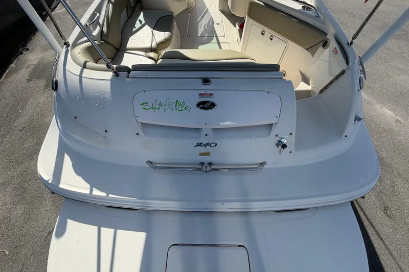 Slide: The Image of The image shows the stern of a 2005 Sea Ray 240 Sundeck boat with a swim platform. - 13