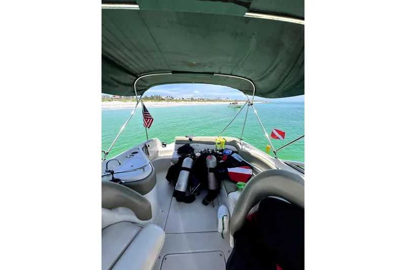 Slide: The Image of 2005 Sea Ray 240 Sundeck with diving gear, anchored near a scenic beach. - 5