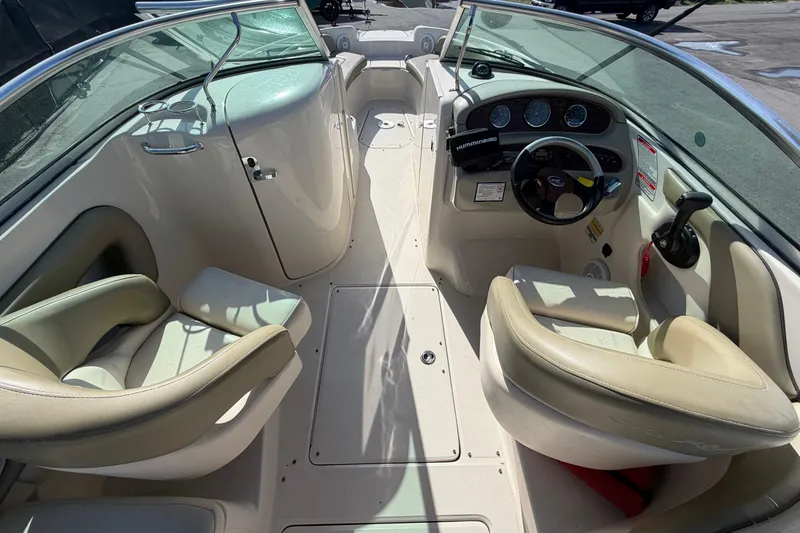Slide: The Image of 2005 Sea Ray 240 Sundeck interior with beige seating and steering console. - 22