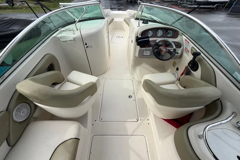 Slide: The Image of 2005 Sea Ray 240 Sundeck interior with dual seating and steering console. - 14