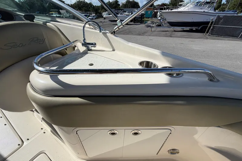 Slide: The Image of 2005 Sea Ray 240 Sundeck interior with sink and cup holders, showcasing luxury boat features. - 16