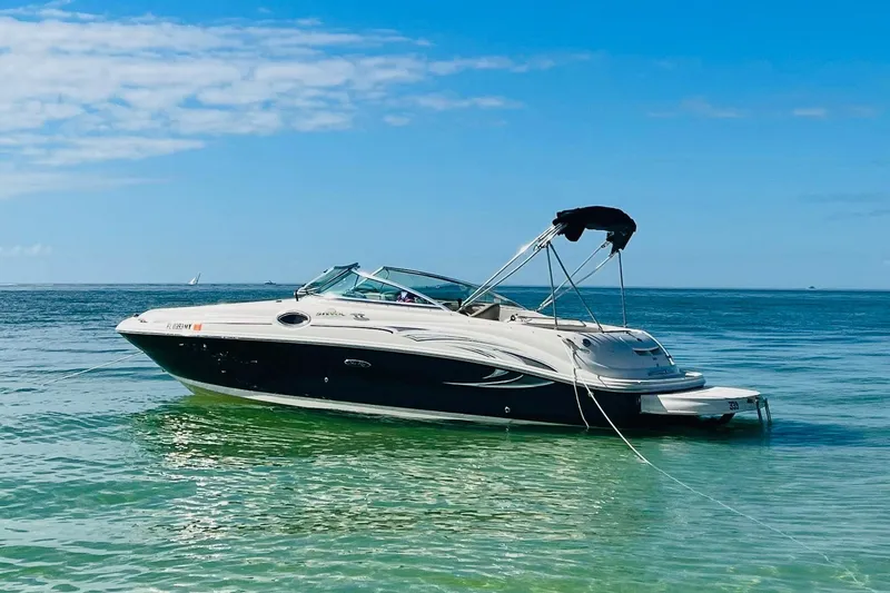 The Image of 2005 Sea Ray 240 Sundeck boat anchored in clear blue ocean waters. - 0