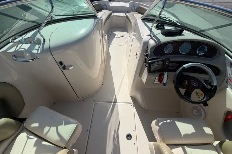Slide: The Image of 2005 Sea Ray 240 Sundeck interior with steering wheel, dashboard, and seating. - 32