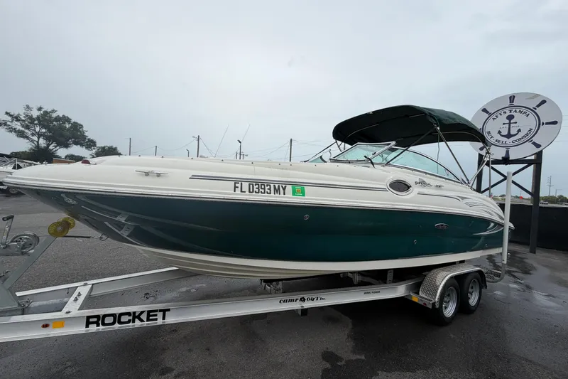 Slide: The Image of 2005 Sea Ray 240 Sundeck boat on trailer, displayed outdoors at a dealership. - 7