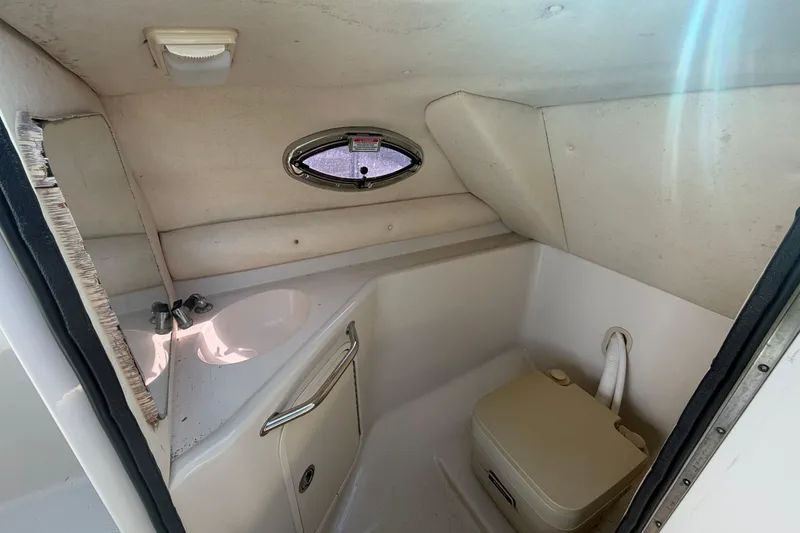 Slide: The Image of 2005 Sea Ray 240 Sundeck interior bathroom with sink and portable toilet. - 38