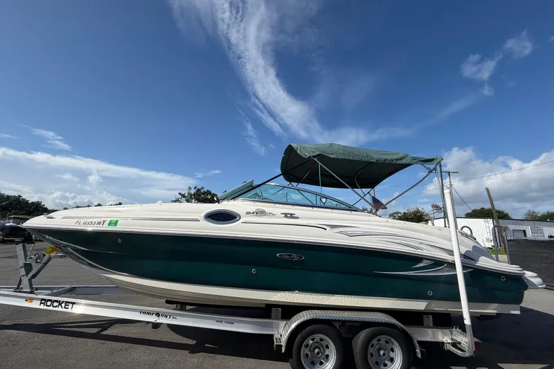 Slide: The Image of 2005 Sea Ray 240 Sundeck boat on trailer under clear blue sky. - 8
