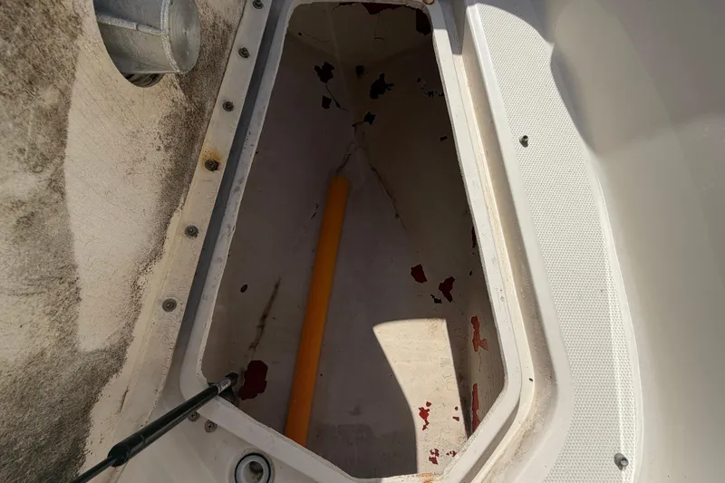 Slide: The Image of An open storage compartment on a boat with a worn interior and a yellow object. - 47