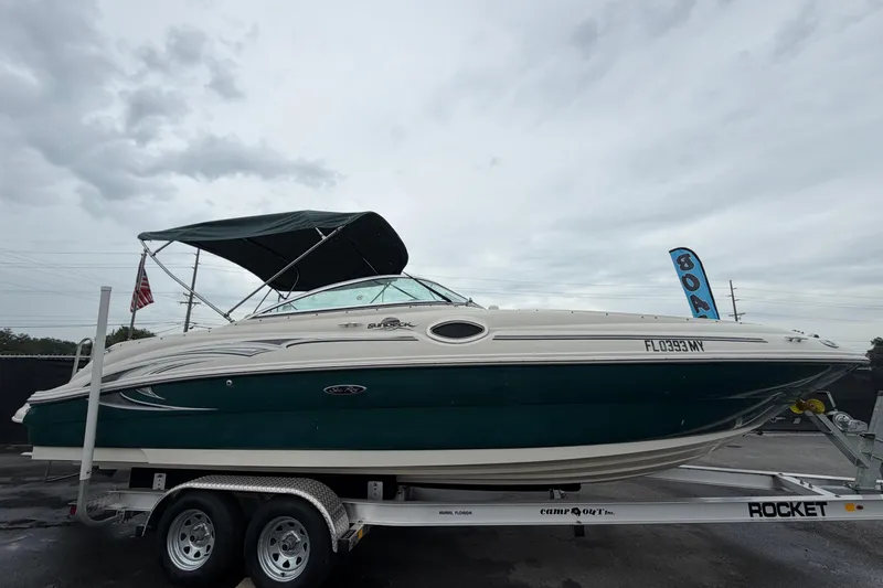 Slide: The Image of 2005 Sea Ray 240 Sundeck boat on trailer under cloudy sky. - 1