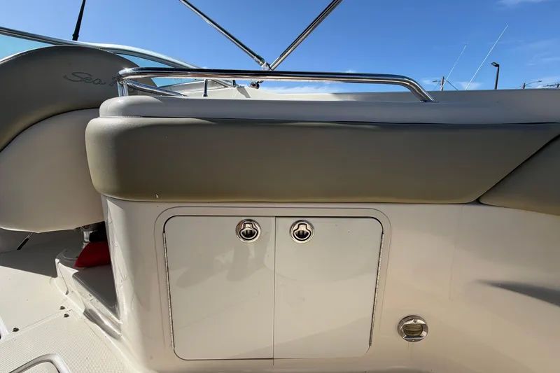 Slide: The Image of 2005 Sea Ray 240 Sundeck interior detail with storage compartment and cushioned seating. - 18