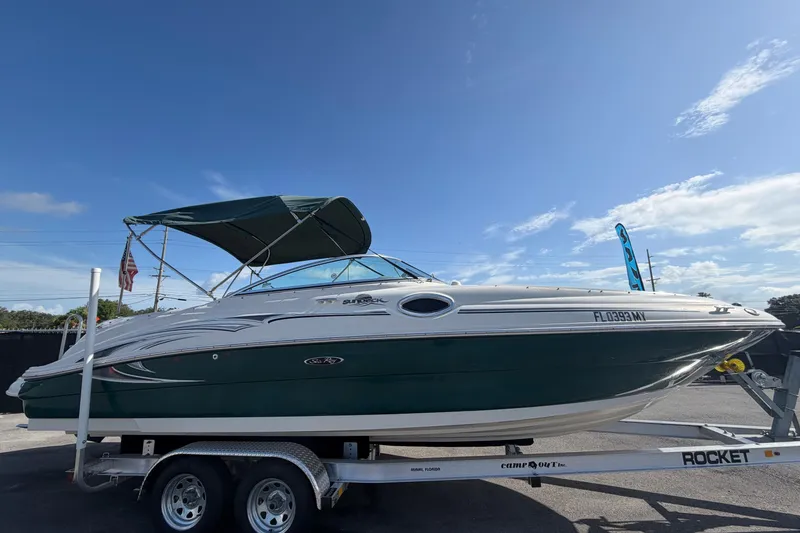 Slide: The Image of 2005 Sea Ray 240 Sundeck boat on trailer under clear blue sky. - 1