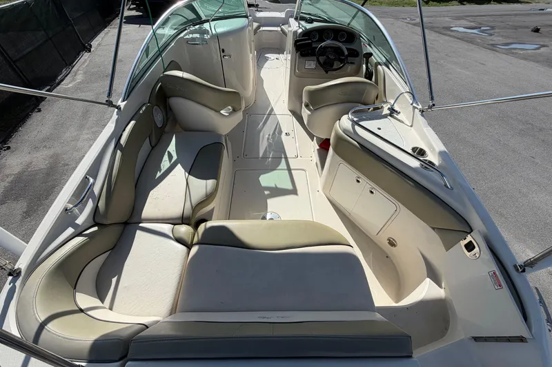 Slide: The Image of 2005 Sea Ray 240 Sundeck interior with seating and helm, showcasing spacious design. - 14