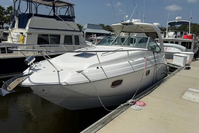 Slide: The Image of 2011 Chaparral 310 Signature boat docked at a marina under a clear sky. - 1