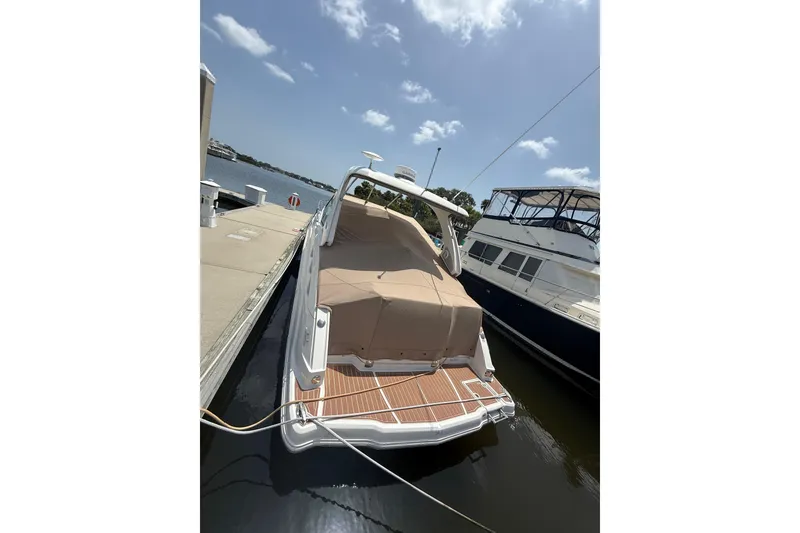 Slide: The Image of 2011 Chaparral 310 Signature boat docked, covered, under a clear sky. - 5