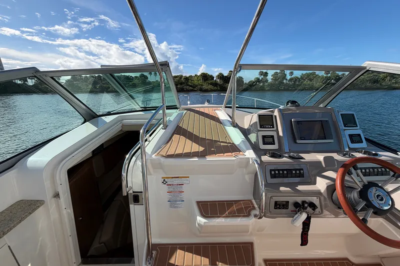 Slide: The Image of 2011 Chaparral 310 Signature boat cockpit with modern controls and scenic water view. - 11