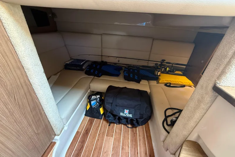 Slide: The Image of 2011 Chaparral 310 Signature cabin interior with seating and fishing gear. - 42