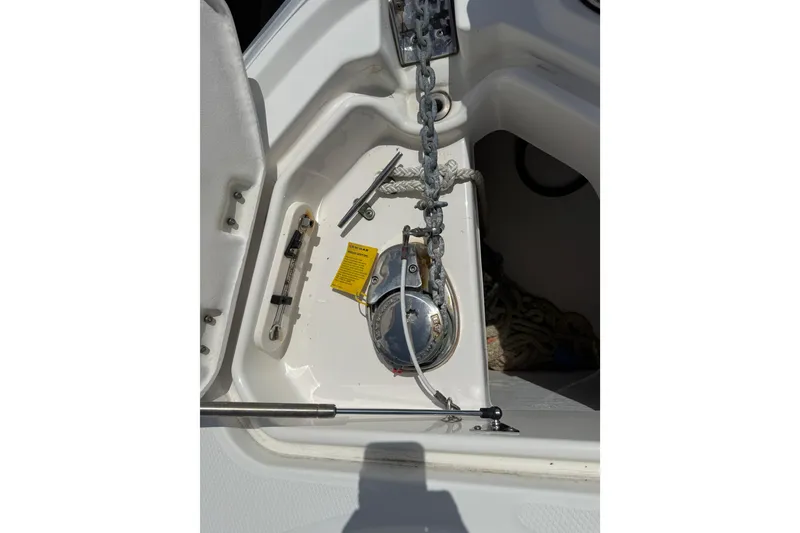 Slide: The Image of 2011 Chaparral 310 Signature boat anchor compartment with chain and winch. - 9