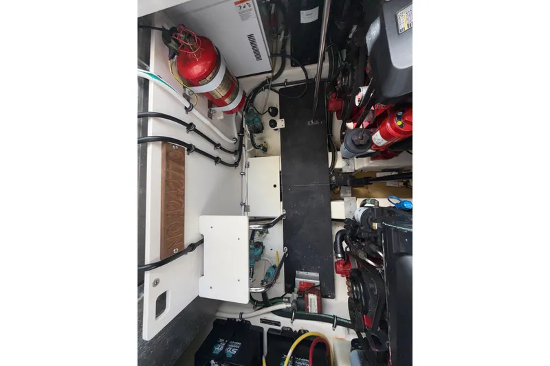 Slide: The Image of Engine compartment of a 2011 Chaparral 310 Signature boat, featuring fire extinguishers and wiring. - 50
