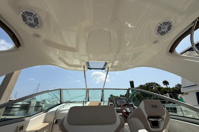 Slide: The Image of Interior view of 2011 Chaparral 310 Signature boat cockpit with steering wheel and seating. - 17