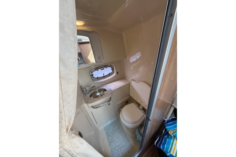 Slide: The Image of 2011 Chaparral 310 Signature boat bathroom with sink, toilet, and window. - 45