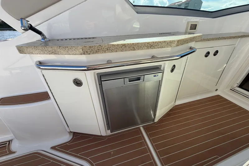 Slide: The Image of 2011 Chaparral 310 Signature yacht kitchenette with stainless steel fridge and granite countertop. - 14