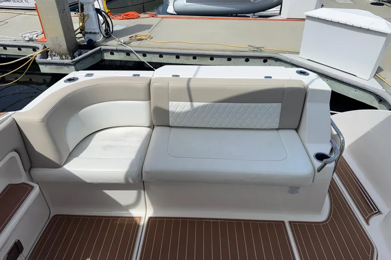 Slide: The Image of 2011 Chaparral 310 Signature boat seating area with white upholstery and wood-patterned flooring. - 16