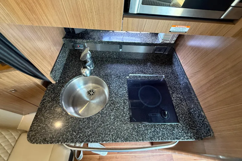 Slide: The Image of Compact kitchen area in 2011 Chaparral 310 Signature boat with sink and cooktop. - 38