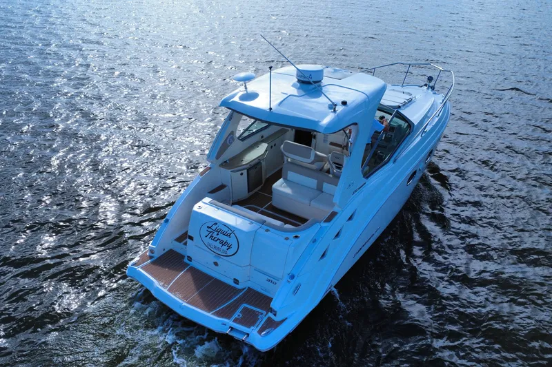 Slide: The Image of 2011 Chaparral 310 Signature boat cruising on open water, rear view. - 6