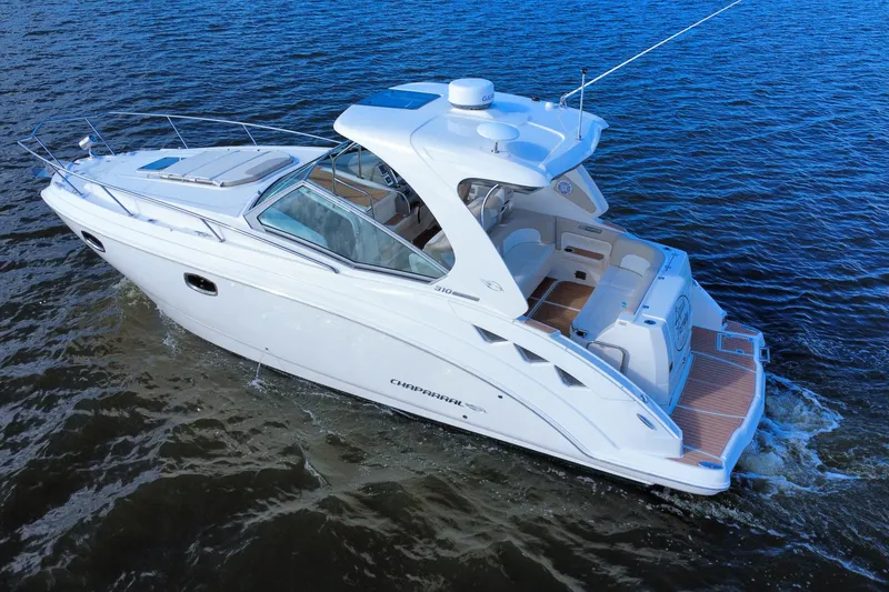 Slide: The Image of 2011 Chaparral 310 Signature boat cruising on open water, showcasing sleek design and luxury features. - 4
