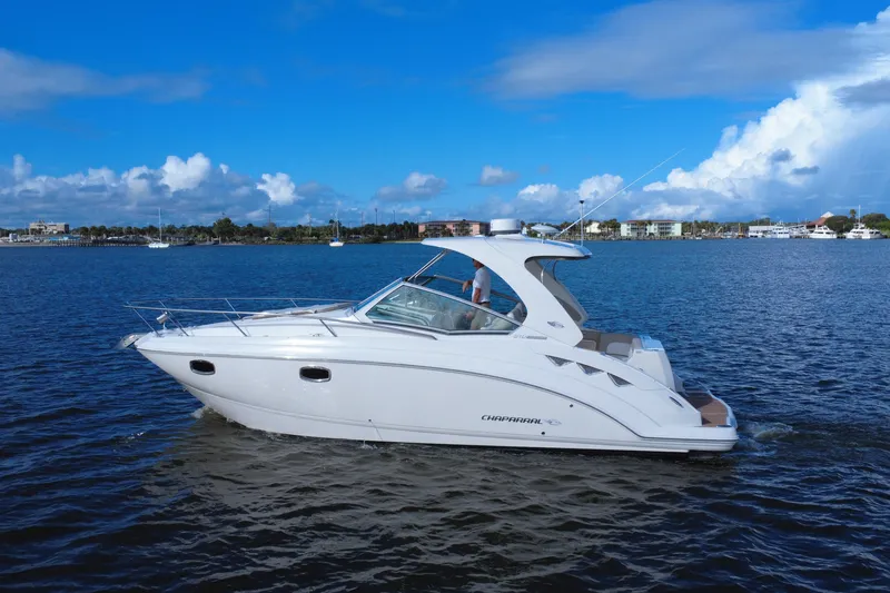 Slide: The Image of 2011 Chaparral 310 Signature boat cruising on a sunny day with blue skies. - 5