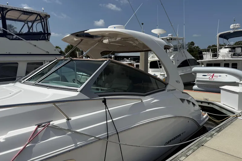 Slide: The Image of 2011 Chaparral 310 Signature boat docked at marina under clear sky. - 3