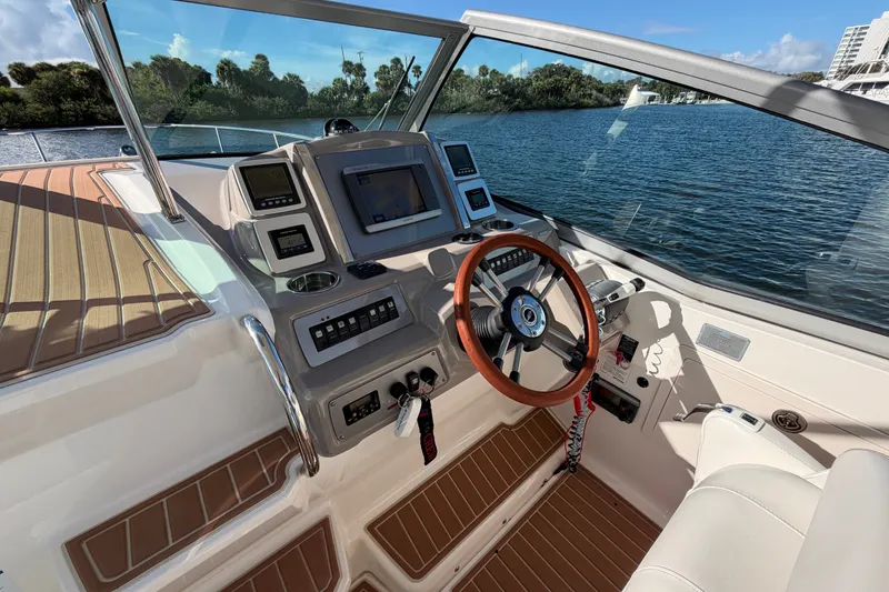 Slide: The Image of 2011 Chaparral 310 Signature boat cockpit with modern controls and wooden steering wheel. - 9