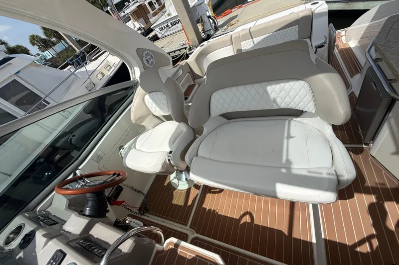 Slide: The Image of Interior of 2011 Chaparral 310 Signature boat with white seating and wooden flooring. - 25