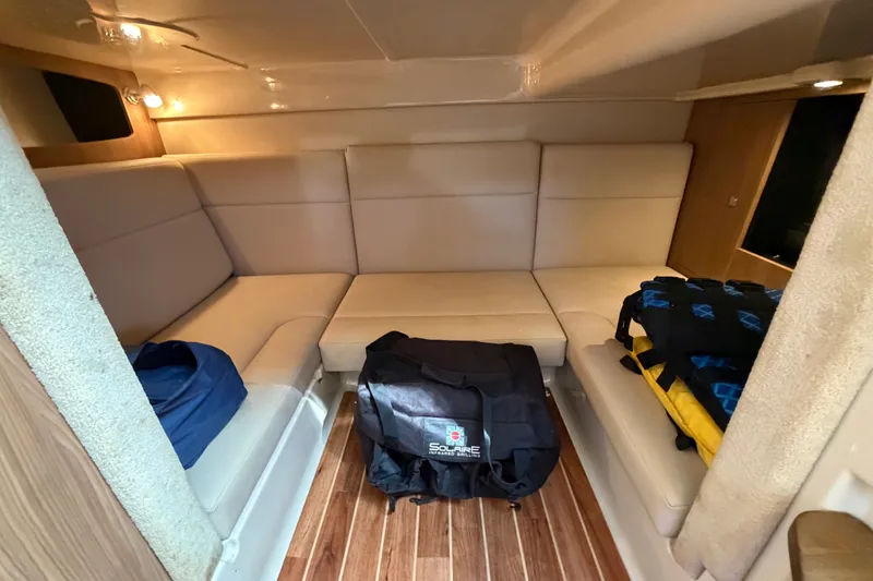 Slide: The Image of Interior of 2011 Chaparral 310 Signature boat with beige seating and wooden flooring. - 25