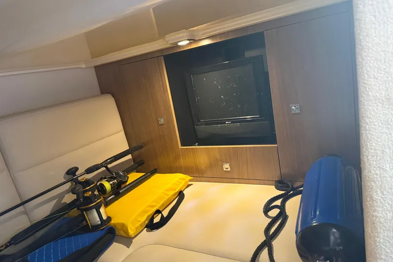 Slide: The Image of Interior of 2011 Chaparral 310 Signature boat with TV, fishing rods, and equipment. - 43