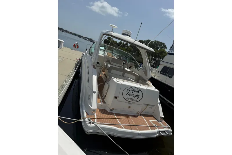Slide: The Image of 2011 Chaparral 310 Signature boat docked, featuring "Liquid Therapy" name on stern. - 7