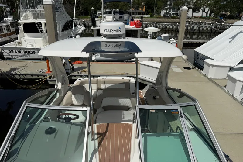 Slide: The Image of 2011 Chaparral 310 Signature boat docked, featuring Garmin equipment and spacious seating. - 13